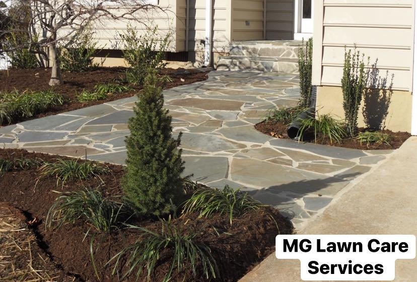Flagstone walkway with fresh mulch beds and plantings, a project by MG Lawn Care Services